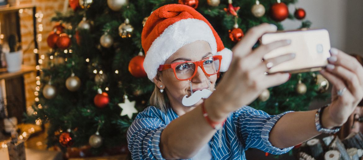 Single-Frau macht Selfie vor dem Weihnachtsbaum fürs Nikolaus Gewinnspiel von Funkenflug